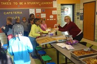 K-Club students getting pizza from Mrs. Abraham