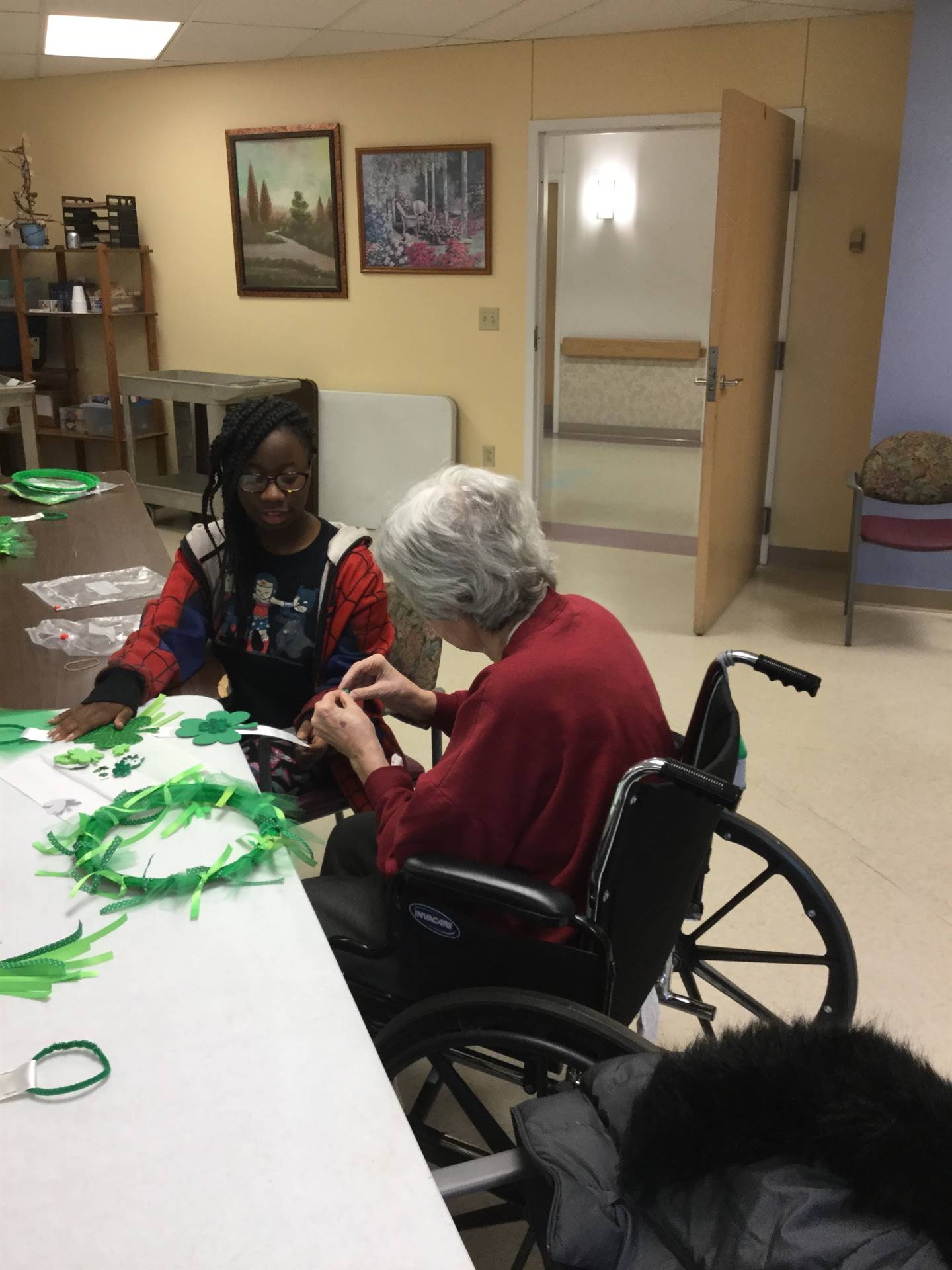 students with residents at Jennings Hall making St. Patrick's Day crafts