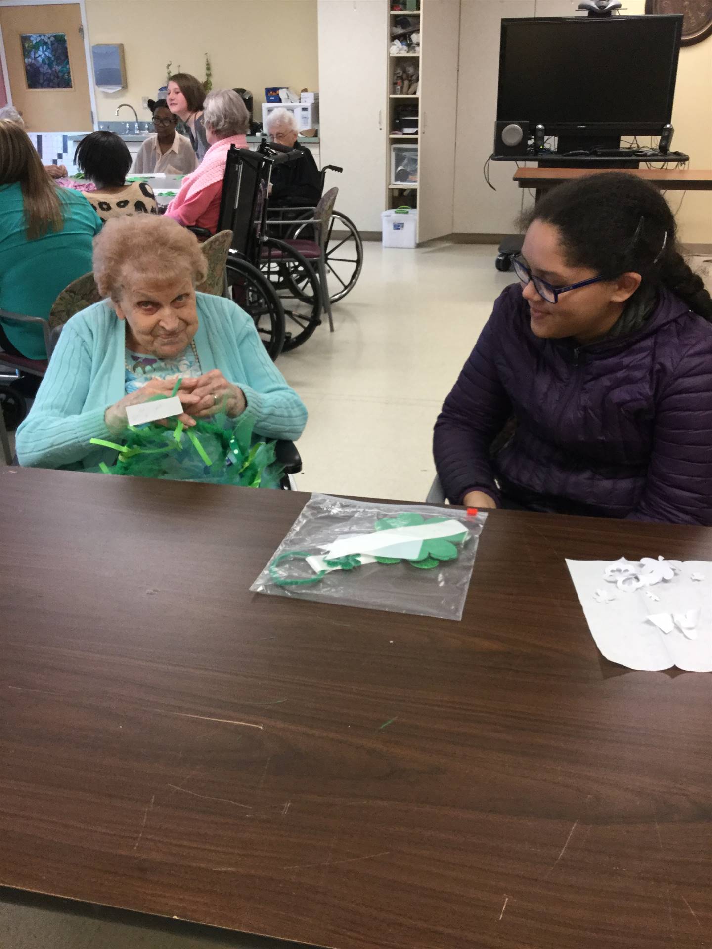 students with residents at Jennings Hall making St. Patrick's Day crafts