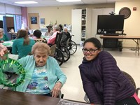 students with residents at Jennings Hall making St. Patrick's Day crafts